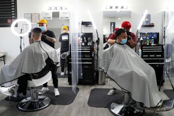 Barbers Mark DeGuzman, foreground, and Romel Diaz at their Hayward shop