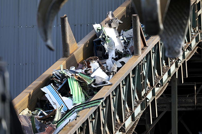  Pieces of scrap metal move on a conveyor belt on to a sorting and shredding process