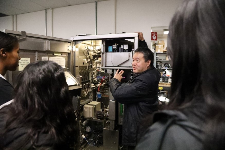 Weldon Chen, Senior Computer Systems Engineer, shows the girls the inside of a Ticket Vending Machine.