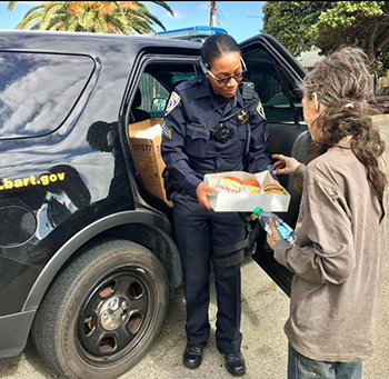 Sgt. Carter gives food and water to a homeless woman