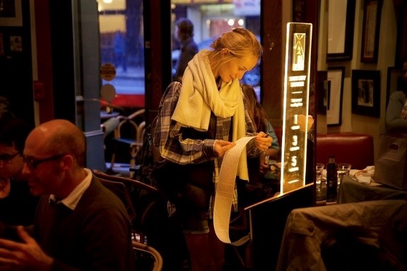 A customer at Café Zoetrope uses a Short Story Dispenser; image by Olivier Alexandre - Short Edition