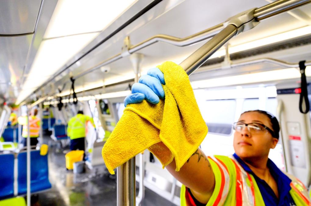 Train car cleaner Alyssa Barnes wipes down a pole on a BART car with disinfectant during a thorough clean.  