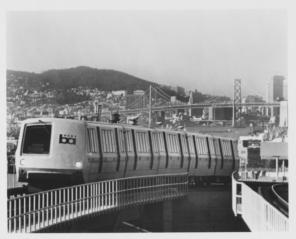 Retro black-and-white photo of BART train heading eastbound with San Francisco in the background