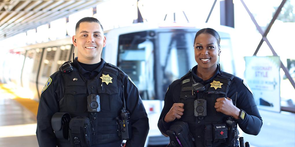 Two BPD officers stand in a BART train station