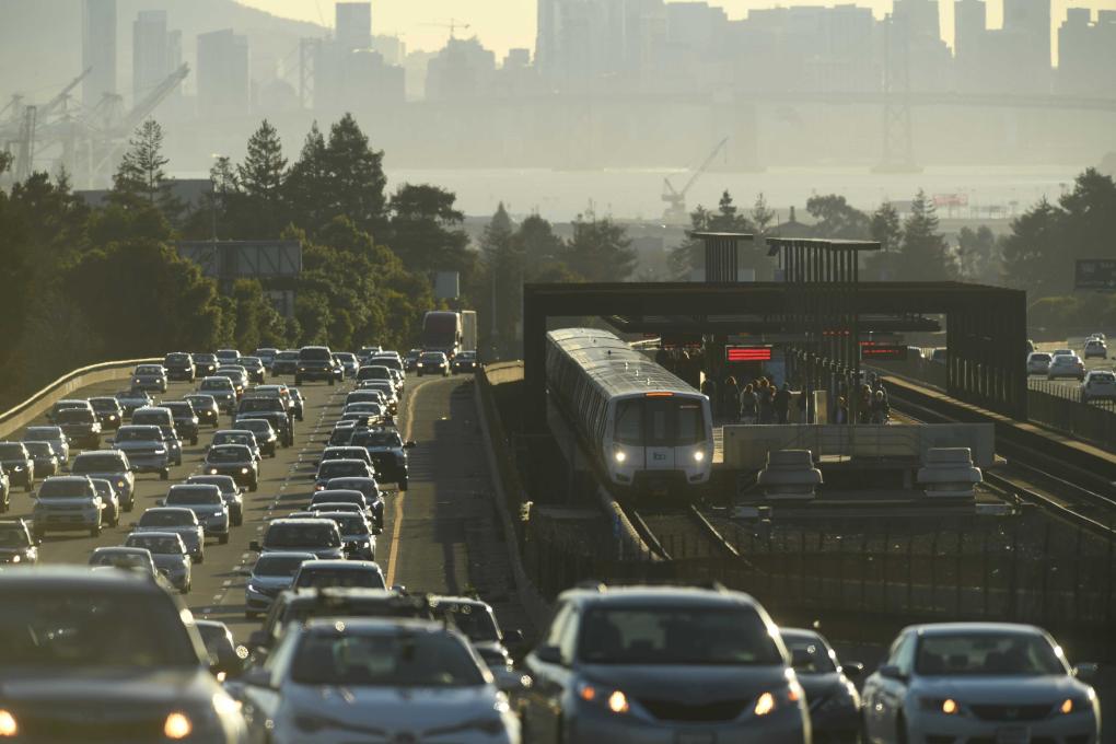 Long lens shot of a BART train surrounded by car traffic by Rockridge Station