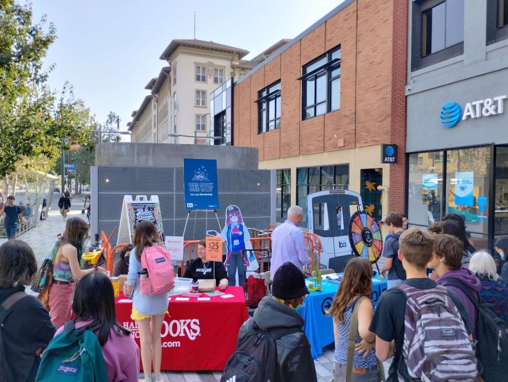 Riders spin the prize wheel, make buttons, and play games with Half Price Books at the One Book One BART Fall ‘23 Book Club kickoff event on Wednesday, Sept. 20, at Downtown Berkeley BART Plaza.  