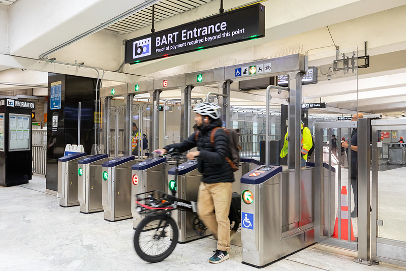 People enter and exit the new fare gates at Civic Center Station