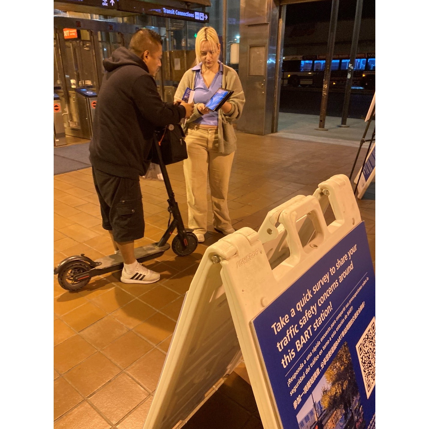 Photo of staff helping a BART customer fill out the survey on a tablet at a pop-up event.