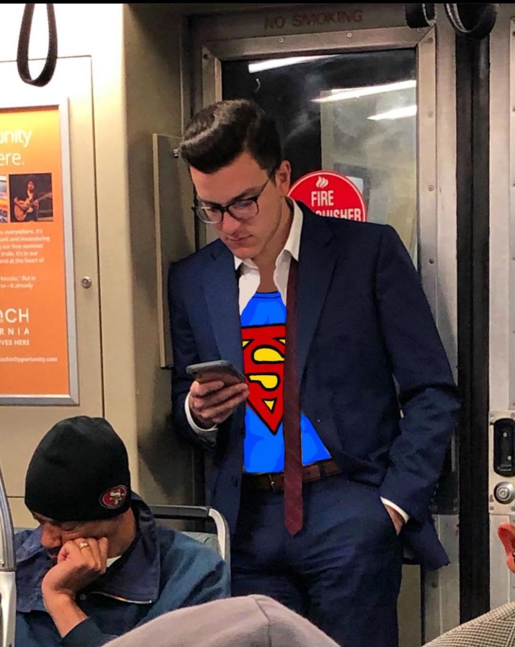 A person dressed in a suit, with a Superman logo humorously edited onto their shirt, is intently looking at their smartphone while riding a subway train, surrounded by other passengers.