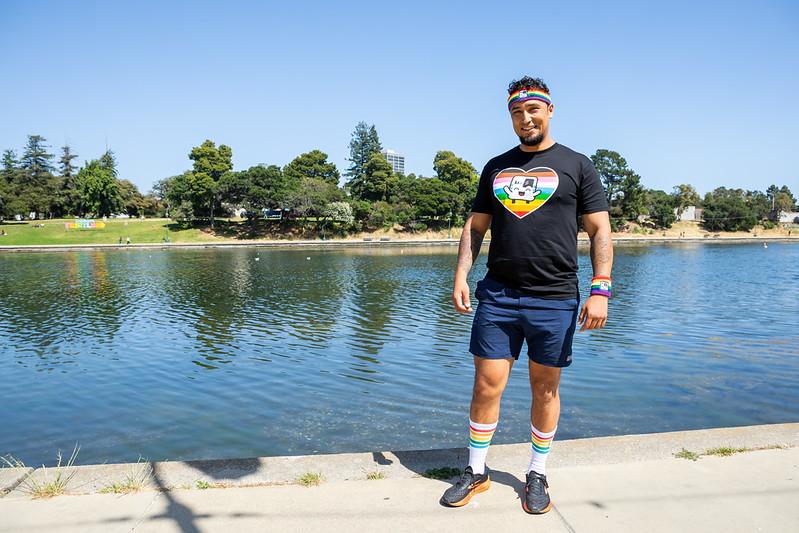 Joshua models the new BART Pride merchandise at Lake Merritt. 